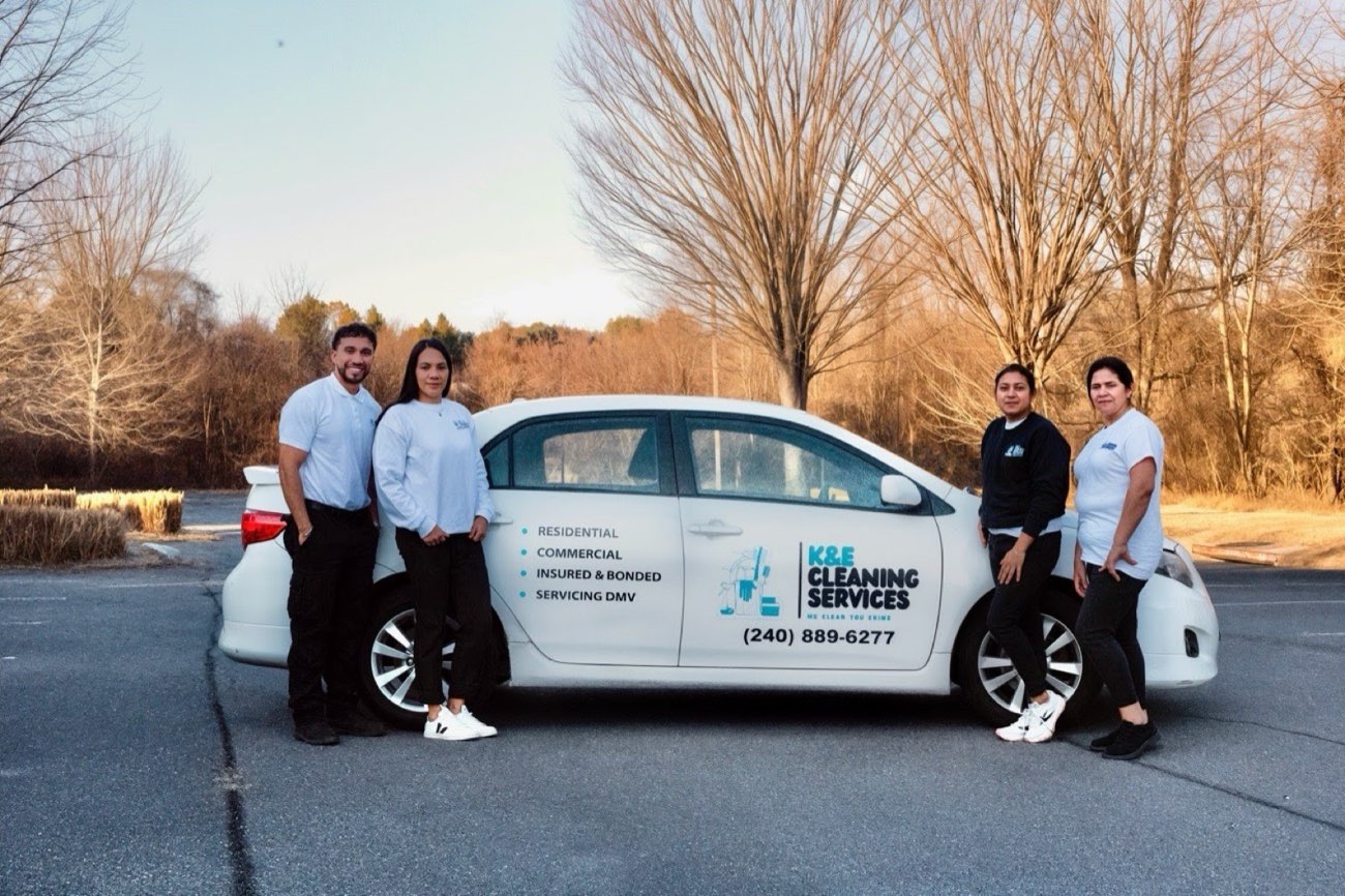 The K&E Cleaning Services team next to their branded service vehicle