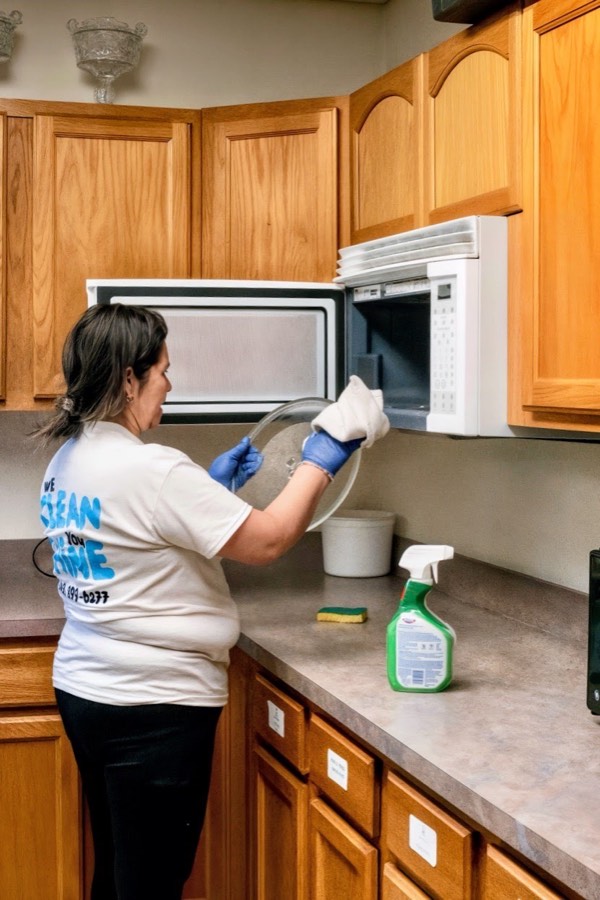 K&E team member cleaning inside a microwave
